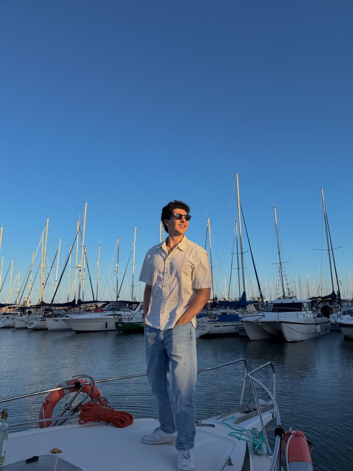 Standing on the bow of a boat in a marina at golden hour